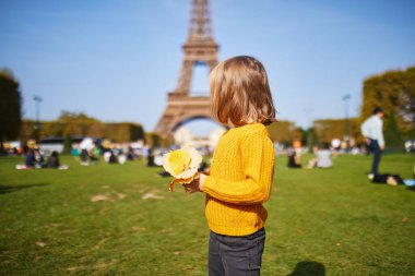 Sevimli mutlu anaokulu kızı Paris, Fransa 'daki Eyfel Kulesi' nin yakınında eğleniyor.