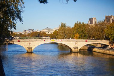 Paris, Fransa 'da güneşli bir sonbahar gününde Pont Louis-Philippe ile Seine nehrinin manzarası