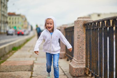 St. Peterburg, Rusya 'daki Fontanka nehri kıyısında yürüyen sevimli anaokulu kızı. Çocuk konseptiyle seyahat etmek