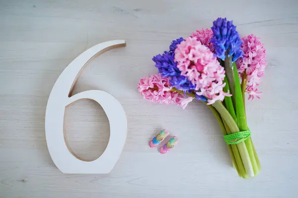 stock image Bunch of light pink and purple hyacinths and white wooden number six. Sixth birthday or anniversary concept.