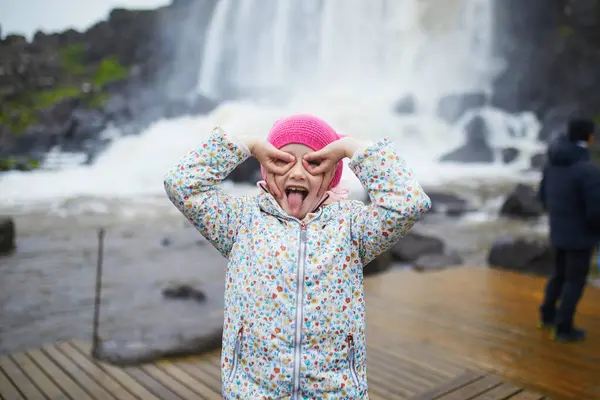 stock image Adorable preschooler girl having fun near waterfall Oxararfoss in Thingvellir National Park, Iceland