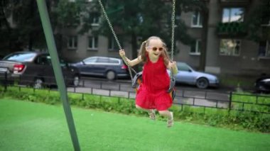 Mutlu 6 yaşındaki kız salıncakta sallanıyor. Oyun bahçesinde tahterevallide sallanan mutlu çocuk. Çocuklar için açık hava yaz etkinlikleri