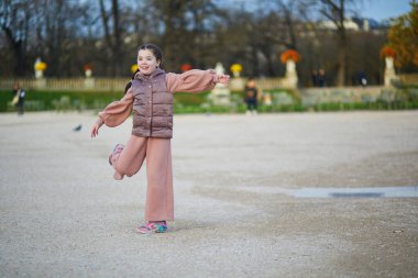 Paris, Fransa 'nın Lüksemburg bahçesinde bir sonbahar gününde eğlenen sevimli küçük kız.