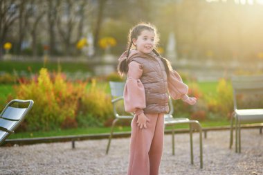 Paris, Fransa 'nın Lüksemburg bahçesinde bir sonbahar gününde eğlenen sevimli küçük kız.