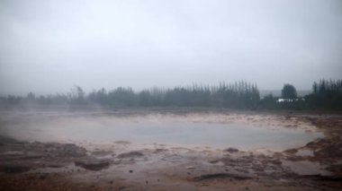 İzlanda 'da sisli bir yağmurlu günde patlamalar arasındaki ünlü Strokkur gayzeri