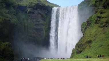 Birçok turist, İzlanda 'nın en büyük şelalelerinden biri olan Skogafoss' un manzarasının keyfini çıkarıyor.