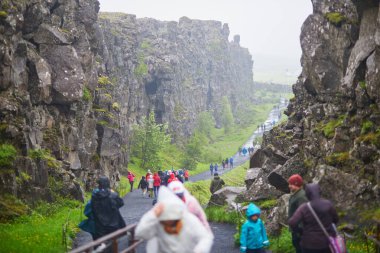 Şeyler, İzlanda - 13 Temmuz 2024: Yağmurlu bir günde İzlanda 'da Thingvellir Ulusal Parkı' nda yürüyüş yapan bir sürü insan