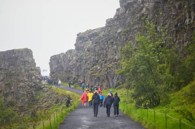 Şeyler, İzlanda - 13 Temmuz 2024: Yağmurlu bir günde İzlanda 'da Thingvellir Ulusal Parkı' nda yürüyüş yapan bir sürü insan