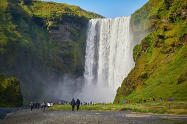 SKOGAFOSS, ICELAND - 15 Temmuz 2024: İzlanda 'nın en büyük şelalelerinden biri olan Skogafoss' un manzarasının tadını çıkaran pek çok turist