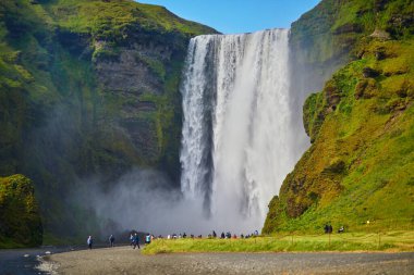 SKOGAFOSS, ICELAND - 15 Temmuz 2024: İzlanda 'nın en büyük şelalelerinden biri olan Skogafoss' un manzarasının tadını çıkaran pek çok turist