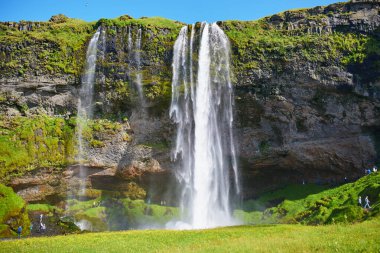 Scenic view of Seljalandsfoss, one of the biggest waterfalls of Iceland, with rainbow clipart