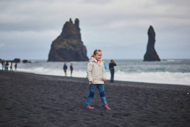 Sevgili anaokulu kızı İzlanda 'da Vik yakınlarındaki Reynisfjara Kara Kum plajında eğleniyor..