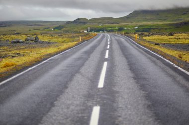 Car driving on a road surrounded by beautiful landscape in Iceland clipart