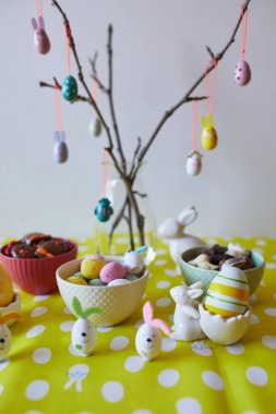 Renkli yumurtalar, tavuklar, lezzetli tatlılar ve çikolatalarla süslenmiş güzel Paskalya masası Paskalya kahvaltısı için servis edilir.