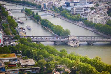 Bir-Hakeim köprüsü, üzerinde metro trenleri ve Paris, Fransa 'da turistik tekneler olan Seine nehrinin havadan manzarası..