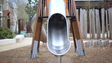 Oyun bahçesinde kaydırağıyla oynayan sevimli mutlu küçük kız.