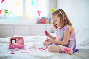 Yeşil etekli şirin anaokulu kızı bir bahar günü parkta ya da ormanda kardelen topluyor..