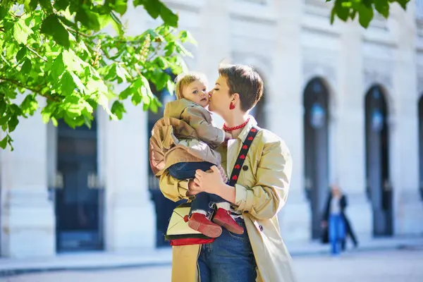 Güzel genç anne ve tapılası küçük kızı Paris, Fransa 'da parkta birlikte yürüyorlar.