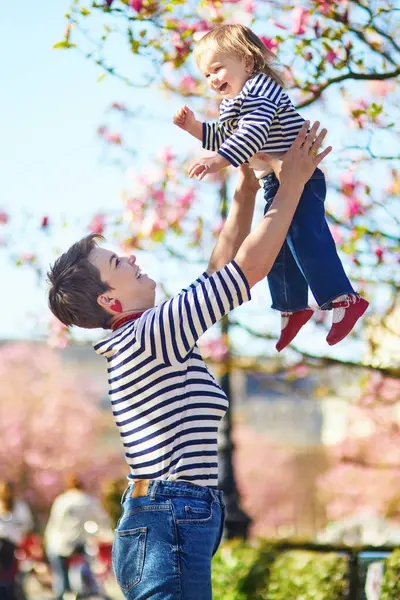 Güzel genç anne ve tapılası küçük kızı Paris, Fransa 'da parkta birlikte yürüyorlar.