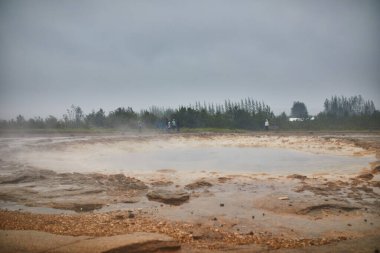 İzlanda 'da sisli bir yağmurlu günde patlamalar arasındaki ünlü Strokkur gayzeri