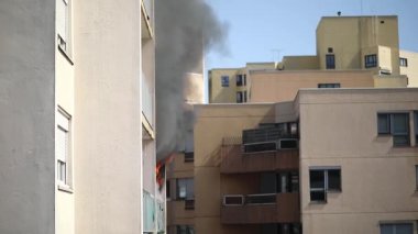 Konut yangını, alevler ve pencereden çıkan duman.