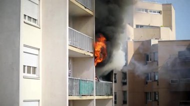 Konut yangını, alevler ve pencereden çıkan duman.