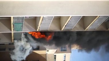 Konut yangını, alevler ve pencereden çıkan duman.