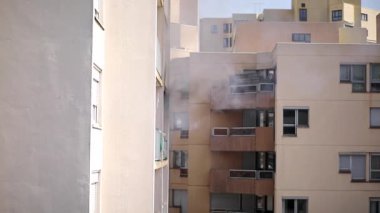 Konut yangını, alevler ve pencereden çıkan duman.