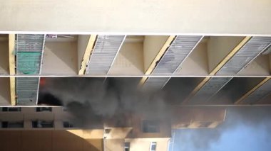 Konut yangını, alevler ve pencereden çıkan duman.