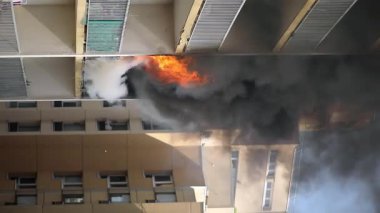 Konut yangını, alevler ve pencereden çıkan duman.
