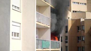 Konut yangını, alevler ve pencereden çıkan duman.