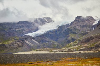 İzlanda 'daki siyah volkanik dağlar ve Vatnajokull (Vatna Buzulu) manzarası