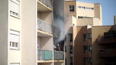 Konut yangını, alevler ve pencereden çıkan duman.