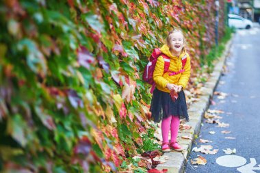 Neşeli liseli kız Paris, Fransa 'daki sonbahar parkında yürüyüşünün tadını çıkarıyor.