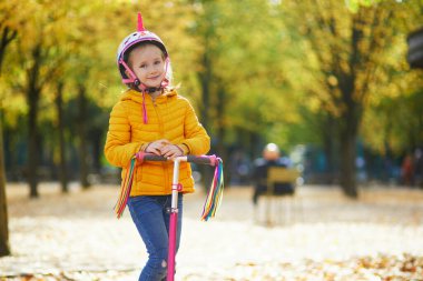 Neşeli küçük kız Paris, Fransa 'daki sonbahar parkında yürüyüşünün tadını çıkarıyor.