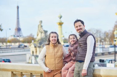 Üç kişilik mutlu bir aile, baba, anne ve kız Lüksemburg 'un Paris bahçesinde birlikte vakit geçiriyorlar.