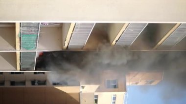 Konut yangını, alevler ve pencereden çıkan duman.