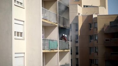 Konut yangını, alevler ve pencereden çıkan duman.