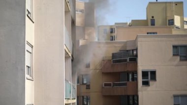 Konut yangını, alevler ve pencereden çıkan duman.