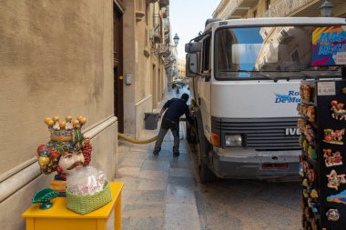 Trapani, Sicilya 'nın batı kıyısında yer alan bir şehirdir. 25 Ekim 2022, Trapani, Sicilya 'da, Trapani' de bir sokakta tuvalet temizleme servisi..