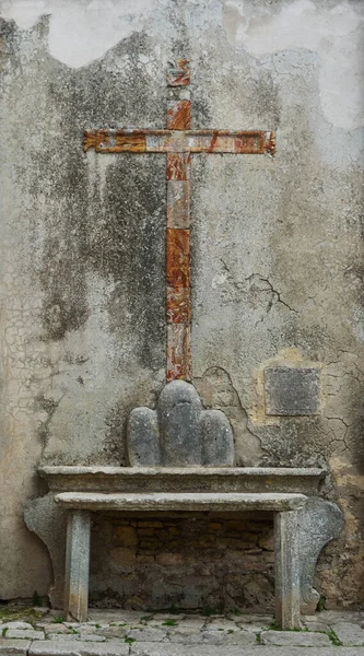 Antique cross on a street in Erice, Italy.