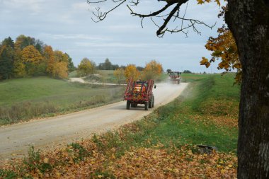 Çakıl yolunda iki traktörlü kırsal alan.