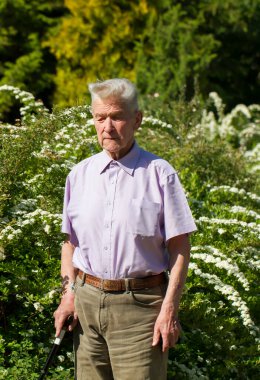 Evin arka bahçesinde yaşlı bir adamın portresi..