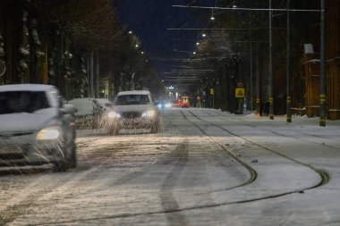 Tramvay ve arabalar kışın Liepaja 'da yolda..