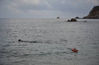 Bir dalış dalgıcı denize dalmaya başlar. Kıyıdan görünüm.