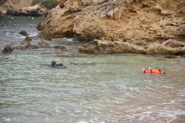 Bir dalış dalgıcı denize dalmaya başlar. Kıyıdan görünüm.