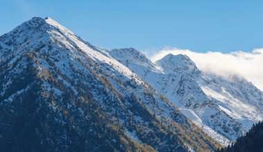 Irkis Vadisi 'nden, Arkhyz' den, Karachay-Cherkessia 'dan, Kuzey Kafkasya' dan. Mavi gökyüzü ve bulutlarıyla karlı dağ vadisi ve Kafkasya 'da Psysh nehrinin yakınında güzel bir orman. Alp manzarası.