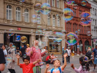 BASEL, SWitzERLAND, 7 Temmuz 2022: Adam baloncuklar üflüyor ve şehir merkezinde çocukları eğlendiriyor. Belediye binasının önündeki meydan.