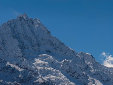 Irkis Vadisi 'nden, Arkhyz' den, Karachay-Cherkessia 'dan, Kuzey Kafkasya' dan. Mavi gökyüzü ve bulutlarıyla karlı dağ vadisi ve Kafkasya 'da Psysh nehrinin yakınında güzel bir orman. Alp manzarası.