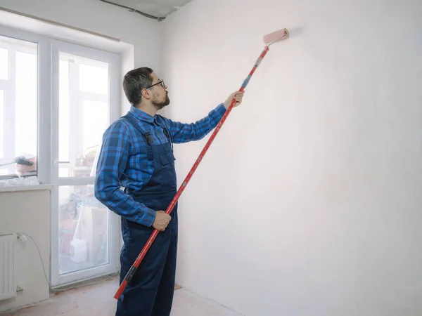 Hombre Joven Traje Trabajo Azul Mantenga Rodillo Pintura Sobre Fondo — Foto de Stock